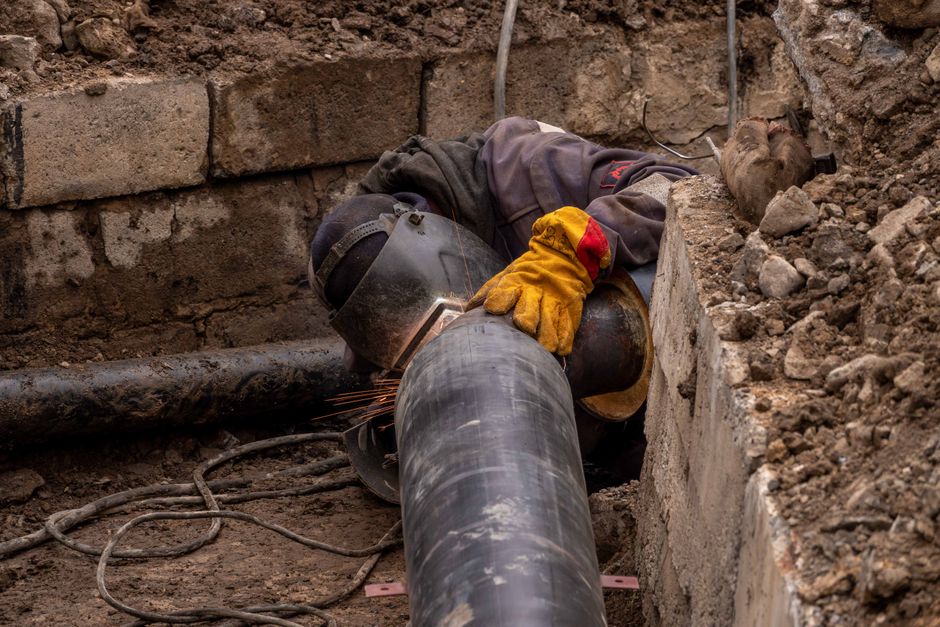 Close-up of a drainage pipe being inspected outdoors in a Bedfordshire garden