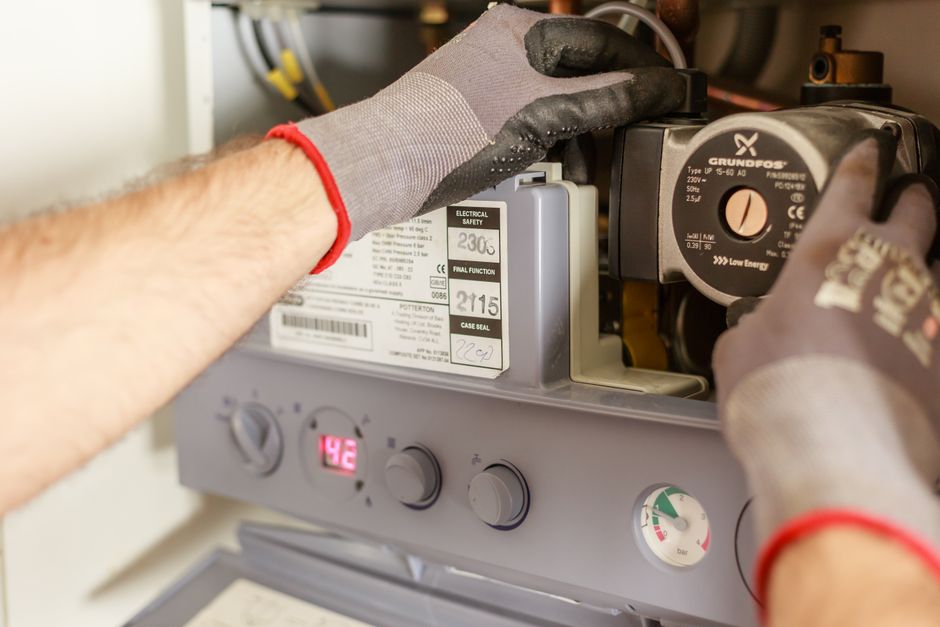 Homeowner using a plunger to unblock a kitchen sink drain